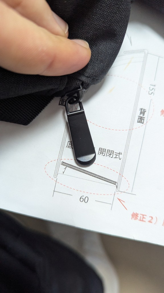 Close-up review of zipper and dimensions against a technical drawing for a custom handbag.